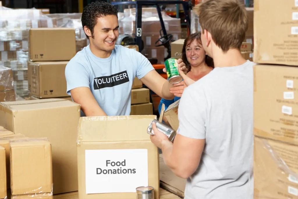 A group of people standing around boxes in a warehouse.