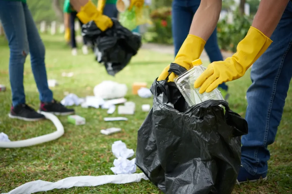 A group of people in yellow gloves picking up trash.