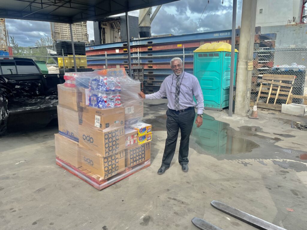 A man standing next to boxes of beer.