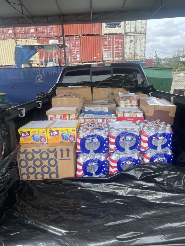 A truck full of boxes and cans is parked in the back.